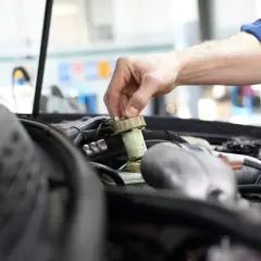 Mechanik sprawdza płyn hamulcowy. Unikaj jazdy bez ważnego przeglądu, by nie ryzykować awarii.