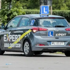 Szara Skoda z literą "L" na dachu i bokach, oznakowana jako "Szkoła Jazdy EXPERT". Tu dowiesz się, gdzie wyrobić profil kierowcy.