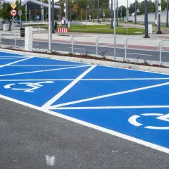 Niebieskie pola z białymi symbolami wózka inwalidzkiego oznaczają parkowanie na miejscu dla niepełnosprawnych.