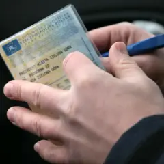 Ręce trzymają dowód rejestracyjny pojazdu. Czy trzeba mieć przy sobie dowód rejestracyjny? Tak, zawsze.
