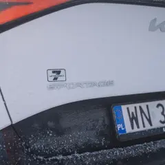 Białe Kia Sportage z polską tablicą rejestracyjną WN 3857R. Widoczny znaczek 7 lat gwarancji.