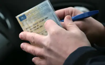 Ręce trzymają dowód rejestracyjny pojazdu. Czy trzeba mieć przy sobie dowód rejestracyjny? Tak, zawsze.