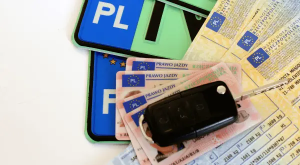 Kluczyki do samochodu, polskie tablice rejestracyjne i kilka dowodów osobistych – wszystko gotowe do odbioru prawa jazdy.