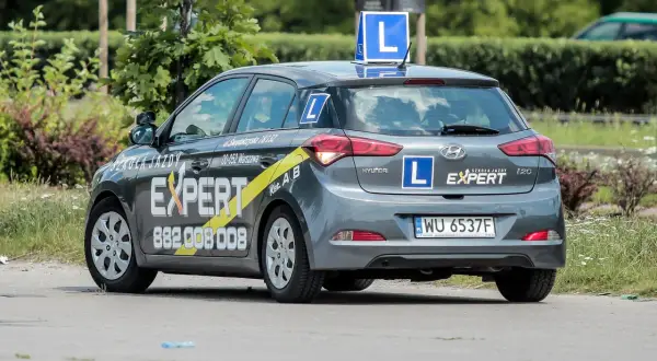 Szara Skoda z literą "L" na dachu i bokach, oznakowana jako "Szkoła Jazdy EXPERT". Tu dowiesz się, gdzie wyrobić profil kierowcy.