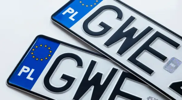 Dwie polskie tablice rejestracyjne z literami "GWE". Nowa rejestracja zbi jest gotowa do drogi.