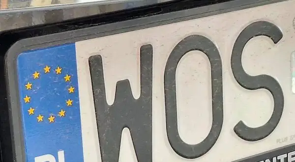 Tablica rejestracyjna z literami WOS i symbolem Unii Europejskiej.