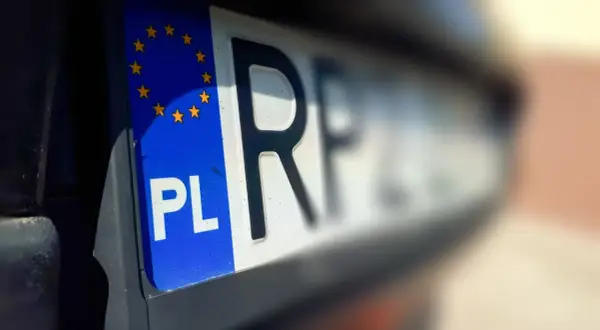 Tablica rejestracyjna z symbolem PL i gwiazdkami UE. Litery "RF" sugerują pozwolenie czasowe pojazdu.