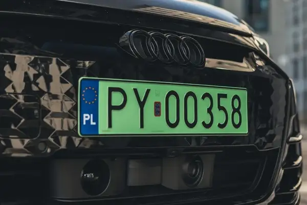 Zielona tablica rejestracyjna PY 00358 na czarnym Audi z czarnymi emblematami. To elw rejestracja, symbol nowoczesności.
