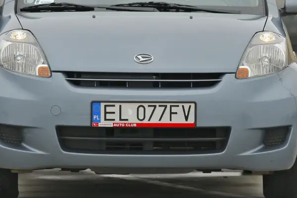 Przód niebieskiego samochodu z tablicą rejestracyjną EL 077FV.