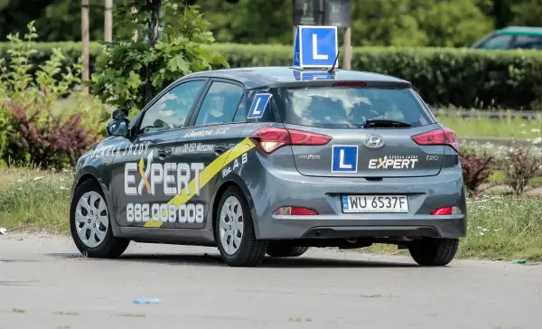 Szara Skoda z literą "L" na dachu i bokach, oznakowana jako "Szkoła Jazdy EXPERT". Tu dowiesz się, gdzie wyrobić profil kierowcy.