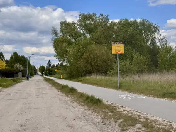 Droga rowerowa z tablicą ostrzegawczą "Kierowco! Za jazdę samochodem po drodze dla rowerów grozi mandat w wysokości do 5000 zł". Czy to rejestracja EPA, jakie miasto?