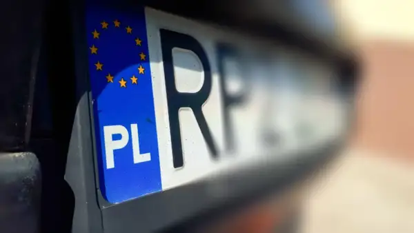 Tablica rejestracyjna z symbolem PL i gwiazdkami UE. Litery "RF" sugerują pozwolenie czasowe pojazdu.