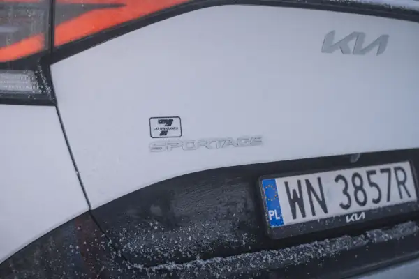 Białe Kia Sportage z polską tablicą rejestracyjną WN 3857R. Widoczny znaczek 7 lat gwarancji.