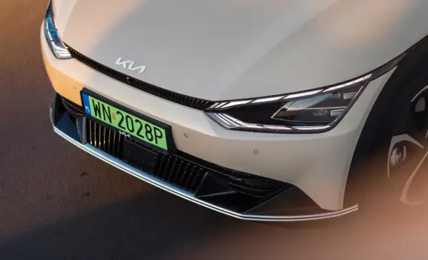 Przód samochodu Kia z zieloną tablicą rejestracyjną WN 2028P.